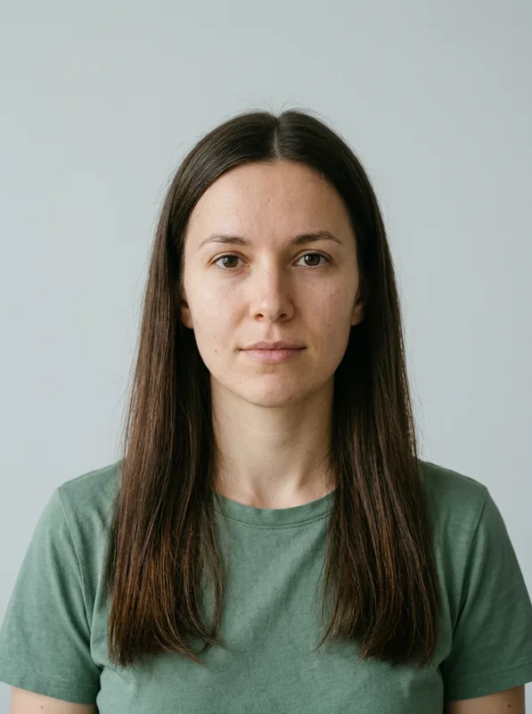 Fictional woman with long dark brown hair, a green shirt, and a gray studio background